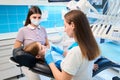 Dental hygienist examines a girls teeth