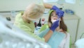 Dental hygienist examining patient teeth with mouth mirror and dental probe