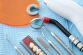Dental instruments and denture lie on a blue medical napkin