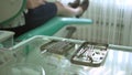 Dental instruments on glass table in dentist office with patient on background