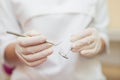 Dental instruments in the hands of the doctor. Dentist in sterile latex gloves holding dental tools detail shoot Royalty Free Stock Photo