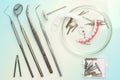 Dental medical tools, dentist equipment: stomatological mirror, false teeth and used dental burs in Petri dish glass on