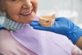 Dental mold of lower teeth close to old female face Royalty Free Stock Photo