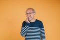 Dental pain. Portrait senior old man sad hand touching cheek suffering from toothache studio shot isolated on yellow background, Royalty Free Stock Photo