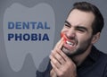 Dental phobia concept. Young man suffering from toothache on background Royalty Free Stock Photo