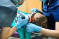 Dental portable tooth X-ray. Little scared girl sitting in chair in dentist doctor office in protective safety