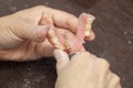 Hands of dental technician make denture prothesis in dental laboratory