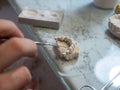 Dental technician modeling dental prosthesis mold in lab using hand tools. Dental restoration, prosthodontics, manual Royalty Free Stock Photo
