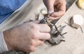 Dental technician processing metal-ceramic crowns on dental model using rotary tool in laboratory, part of prosthodontic Royalty Free Stock Photo