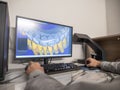Dental technician using CAD software to design digital 3D model of patient teeth for prosthetic restoration Royalty Free Stock Photo