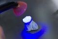 Dental technician using dental curing light in a tooth. Royalty Free Stock Photo