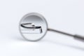 Dental tool reflected in the mirror on white background