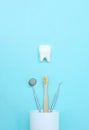 Dental tooth model with metal medical dentistry equipment tools - teeth dentist mouth mirror, toothbrush in white glass Royalty Free Stock Photo