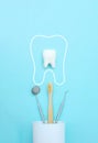 Dental tooth model with metal medical dentistry equipment tools - teeth dentist mouth mirror, toothbrush in white glass, dental Royalty Free Stock Photo