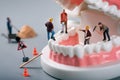 Dental treatment concept - construction workers figurines on tooth model