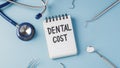 Dental treatment cost concept with dentist instruments on blue background