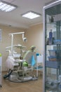 Dental treatment room with modern green chair. Orthodontic chair in small stomatology cabinet. Dental office.Dental office Royalty Free Stock Photo