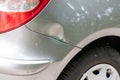 Dented car wing and fender with scratches and bumps after crash and car accident with hit-and-run driving and absconding shows nee