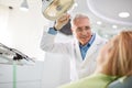 Dentist adjust searchlight before starting work Royalty Free Stock Photo
