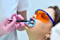 Dentist applies whitening gel to patient`s teeth i