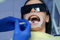 Dentist is applying blue acid on woman& x27;s teeth before installing veneers.