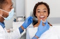 Dentist applying invisible aligner on female patient teeth