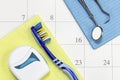 Dentist appointment date on calendar with toothbrush floss and tools dental appointment concept