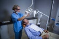 Dentist assistant adjusting light over patients mouth