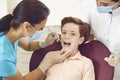 Dentist and assistant check the teeth of a boy child in a dental clinic