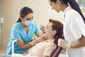 Dentist and assistant check the teeth of a boy child in a dental clinic.