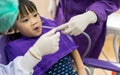 Dentist and assistant checking and cleaning asian girls teeth us Royalty Free Stock Photo