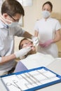 Dentist and assistant in exam room with man