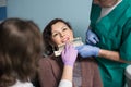 Dentist with assistant and female patient checking and selecting colour of the teeth in dental clinic office Royalty Free Stock Photo
