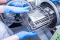Dentist assistant`s hands get out sterilizing medical instruments from autoclave. Selective focus Royalty Free Stock Photo