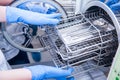 Dentist assistant`s hands get out sterilizing medical instruments from autoclave. Selective focus