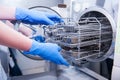 Dentist assistant`s hands get out sterilizing medical instruments from autoclave. Selective focus Royalty Free Stock Photo