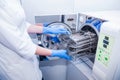 Dentist assistant`s hands get out sterilizing medical instruments from autoclave. Selective focus Royalty Free Stock Photo