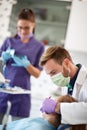 Dentist with assistant working in dental ambulant with patient