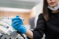 Dentist in blue gloves taking drill of dental machine instrument panel in stomatology clinic