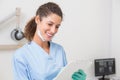Dentist in blue scrubs writing on clipboard Royalty Free Stock Photo