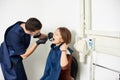 Dentist in a blue uniform is curing the patient in a white dental office