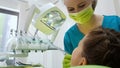 Dentist carefully drilling kids tooth, modern pediatric stomatology clinic