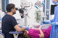 Dentist checking teeth of young woman with dental microscope in modern clinic Royalty Free Stock Photo