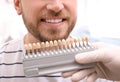 Dentist checking young man`s teeth color Royalty Free Stock Photo