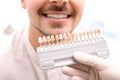 Dentist checking young man`s teeth color Royalty Free Stock Photo