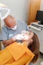 Dentist checks a young girl`s teeth in his office