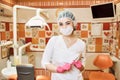 Children`s doctor dentist girl in the dental office holding a tool Royalty Free Stock Photo