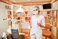 Children`s doctor dentist girl in the dental office holding a tool