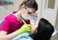 Dentist cleaning teeth of woman