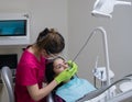 Dentist cleaning teeth of woman